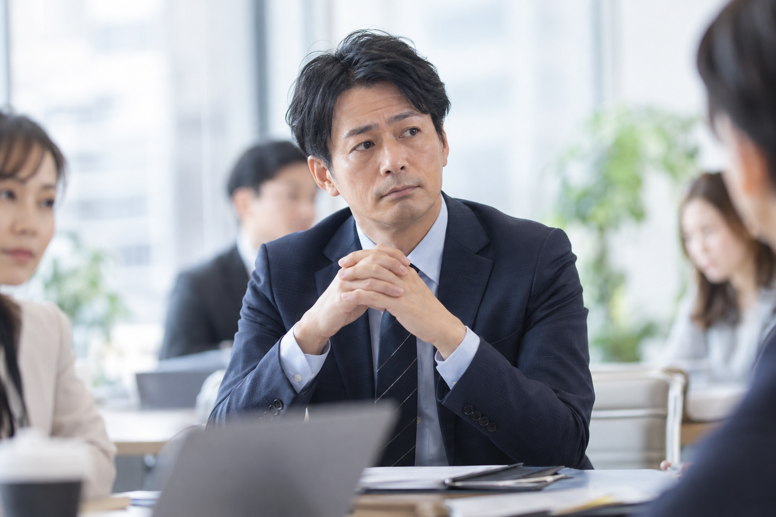 会議で周囲の評価を気にする働く男性